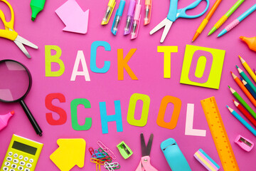 School supplies with inscription back to school on pink concrete background
