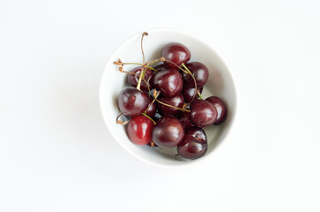 Cherry in a white plate on a white background