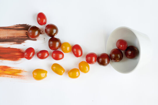 Colorful tomatoes on a white background scattered