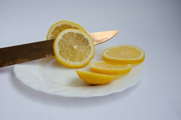 Sliced juicy lemon and a knife, slices of lemon close up.