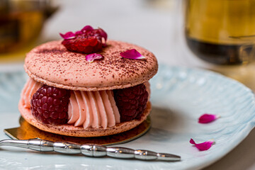 Pink Raspberry Macaron cookies on blue plate. Tea time. Blue table background. Top view. 