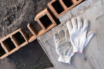 Garden tools, gloves and beautiful flowers, leaves and plants on a concrete background. The concept...