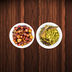 round red chillies and spices in white bowls in a nice wooden background
