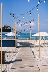 beautiful beach. with a wooden walkway, thatched roof gazebo and beautiful white umbrellas
