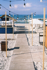 beautiful beach. with a wooden walkway, thatched roof gazebo and beautiful white umbrellas
