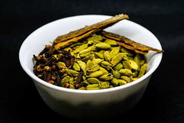 isolated view of spices in a white bowl with black background