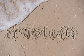 Fototapeta premium the word problem written in sand that is washed off by a sea wave 