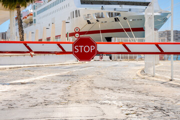 Stop sign in barrier. Closed access for the ship in the port. Travel restrictions.