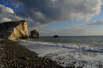 Paphos. Cyprus. Petra tou romiou. Aphrodite's rock. View from the postcard dramatic stormy sky over the sea. Rocks in the sea. The birthplace of the goddess Aphrodite. Romantic beach for lovers. 