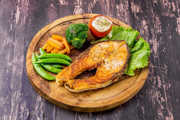Salmon steak on wooden plate