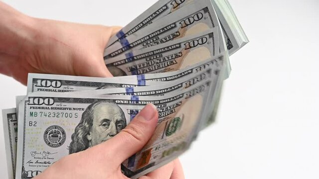 Man hand counting us dollars with nominal of 100, slow motion close up