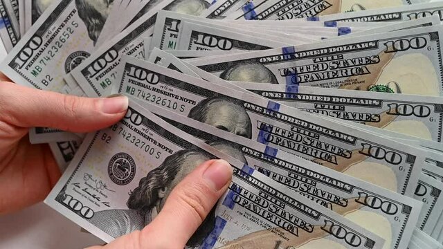 Man hand counting us dollars with nominal of 100, slow motion close up