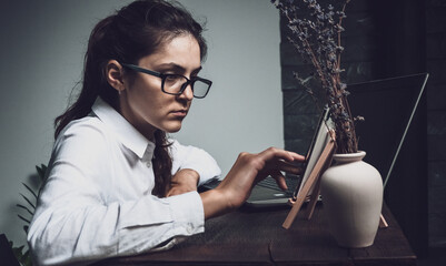 The girl in glasses works from home on the computer and conducts an online broadcast. Girl at a...