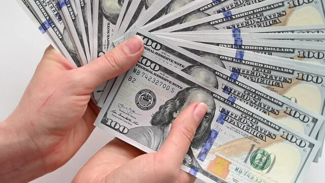 Woman hand counting us dollars with nominal of 100, slow motion close up
