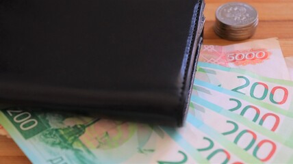 Russian money with a black wallet on the table close-up