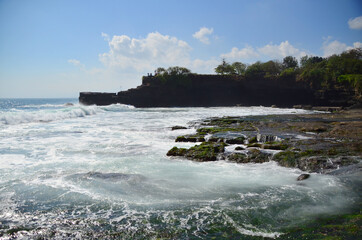 Tanah Lot is a rock formation off the Indonesian island of Bali. It is home to the ancient Hindu pilgrimage temple Pura Tanah Lot, a popular tourist and cultural icon for photography.