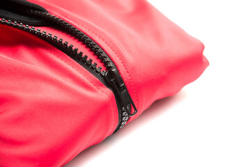 Folded red zipper windbreaker jacket, UV sun proof outdoor jacket hoodie. Track jacket sport hoodie full zip isolated on white background. Folded clothes.