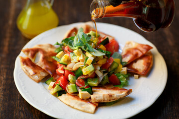 Salad with vegetables and croutons, pouring sauce