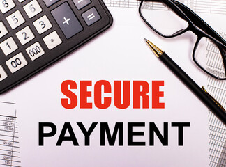 Fototapeta premium SECURE PAYMENT is written in black on a white background near a pen and glasses in a black frame. Business concept. Top view close up