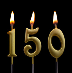 Gold birthday candles on black background, number 150