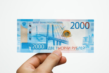 2000 rubles in a man’s hand on a white background.