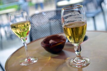 Verre de bière et verre de vin blanc sur une table