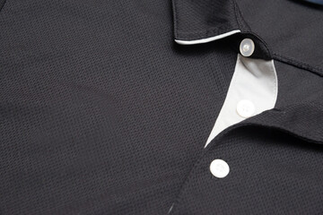 Blank black polo shirt with three white buttons. Polo shirt isolated on white background. Men's clothing.