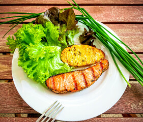 Grilled salmon fillet with potato and salad