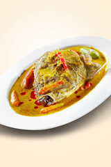 Snapper fish curry head. Snapper's head is cooked with coconut milk and herbs with starfruit vegetable and whole chillies.