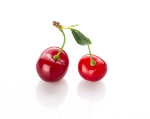 fresh cherry berries with a green leaf isolated on a white background