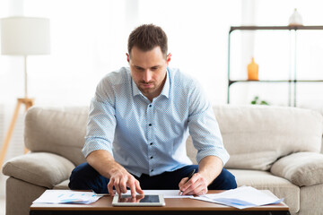 Business man using tablet at home and writing notes