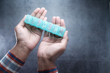 man hand holding pill box top down 