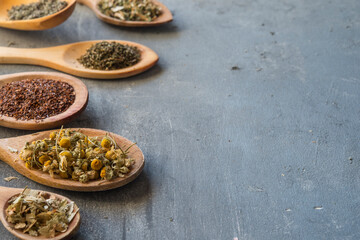 herbs with wooden spoon in gray slate background