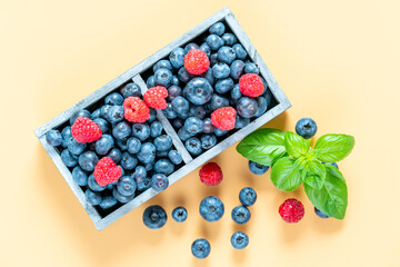 blueberries and raspberries in wooden crates.