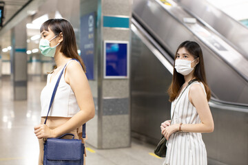 Young asian  business woman cover mouth and cough, wear medical face mask to protect viruses.standing distance of 1 meter from other people keep distance protect from COVID-19 viruses.social distance.