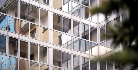 A tall glass business building with reflections 