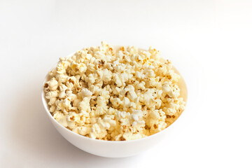 Popcorn in a white plate on a white background.Cooked popcorn.