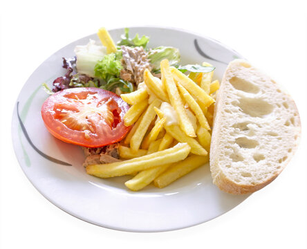Plate of food. French fries, tomato, salad and bread. Isolated image on a white background. 