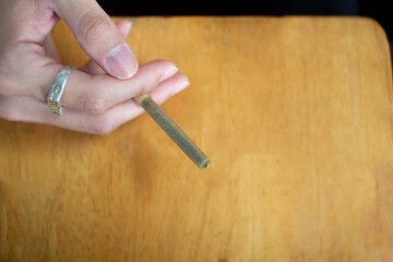 Marijuana joint in the hand, drugs concept,Happy man smoking weed