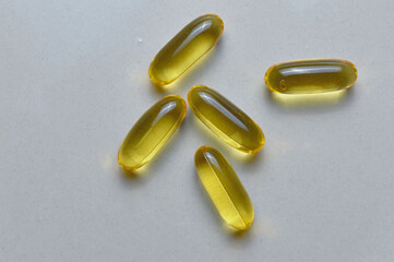  Capsules with fish oil on light background