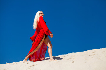 Fototapeta premium Sexy young beautiful blonde girl in black bikini and red tunic