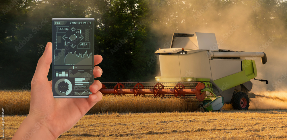 Aufkleber A farmer controls an autonomous combine harvester with a smartphone mobile application