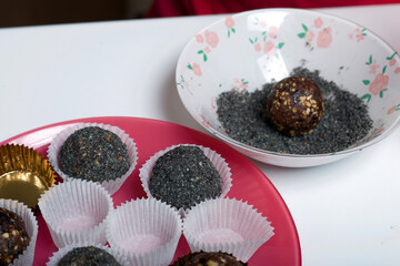 Dried fruit sweets. Balls of prunes, dates and coconut. With a sprinkle of black sesame powder.