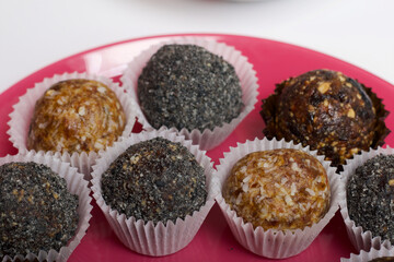 Dried fruit sweets. Balls of prunes, dates and coconut. With a sprinkle of black sesame powder.