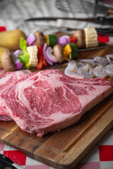 fresh ribeye steak with skewered shrimp and vegetable
