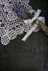 Dry lavender flowers bouquet on old lace and rustic wooden background.