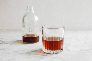 A glass of cold brew coffee and a bottle