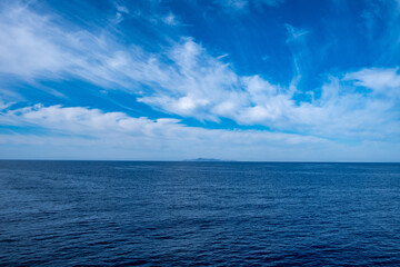 Obraz premium Blue sea and sky background, blue shades and white clouds
