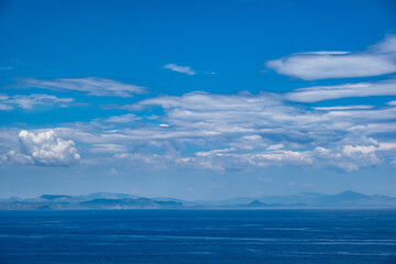 Blue sea and sky background, blue shades and white clouds