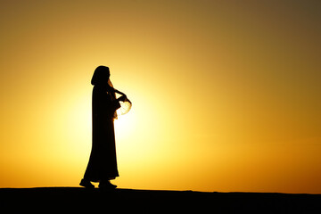Woman model silhouette in an amazing sunset in the desert